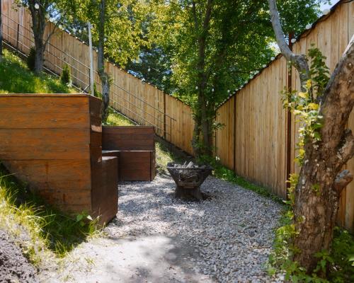 a wooden fence with a bench in a yard at Secluded Cabins with Mountain & Sunset Views in Almaty