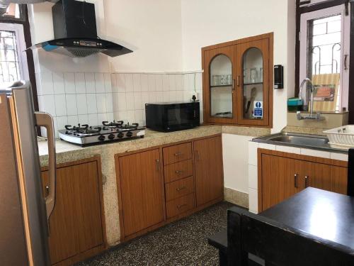 una cucina con mobili in legno e un forno a piano cottura di Shanti Apartment 2BHK Thamel 5 min walk 2nd Floor a Thapathali
