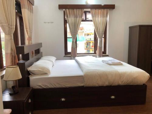 una camera da letto con un letto grande con una finestra di Thamel apartment Thamel 5 min walk 1BHK 3rd Floor a Thapathali