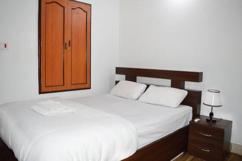 ThapathaliKathmandu Apartment 1BHK Thamel 5 min walk 0 Floor的一间卧室，有两张床、一个橱柜和一张床 sidx sidx