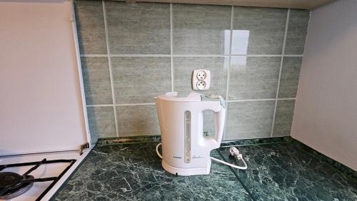 une cuisine avec un mixeur posé au sol à côté d'une cuisinière dans l'établissement M przy Broniewskiego, à Łomża