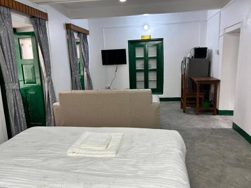 ein Schlafzimmer mit einem Bett und zwei grünen Türen in der Unterkunft Buddha Apartment - Traditional house in Thamel in Thapathali