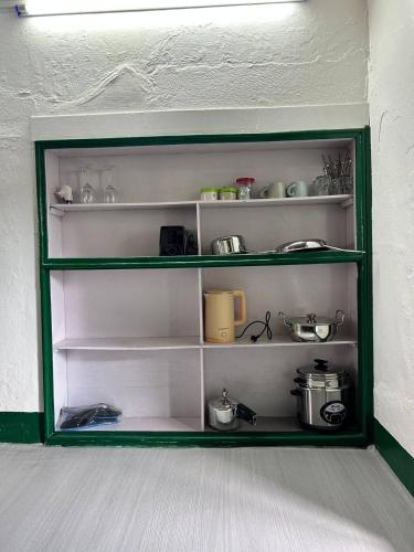 ThapathaliGanesh Apartment, Traditional house in Thamel的房间里有一个绿色的架子，上面放着餐具。