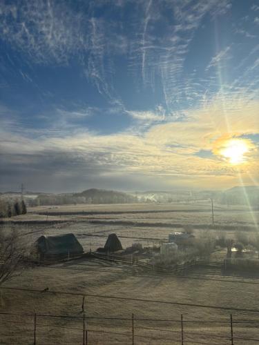 Una vista de un campo con tiendas de campaña y la puesta de sol. en Apartament Gołębiewscy, en Boguszów-Gorce