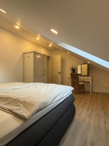 a bedroom with a large bed and a desk at Landhausstübchen 105qm mit Balkon-2 Schlafzimmer-Bad-WC-WiFi-Kaffeemaschine-Waschmaschine-Trockner-Föhn-Handtücher und Bettwäsche-sehr familienfreundlich in Eichenzell