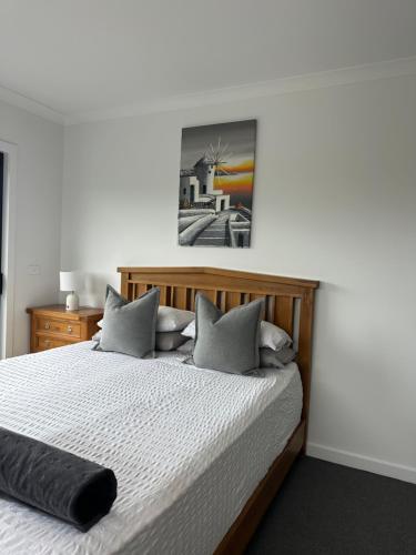 a bedroom with a large wooden bed with pillows at McCrae Retreat Brand New Home in McCrae