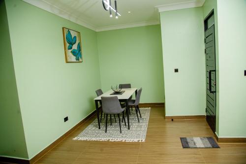 una sala da pranzo con tavolo e sedie di Mercella Homes - Munyonyo a Kampala