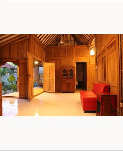 ギリ・アイルにあるSunset Side Gili Homeの赤いソファと木製の壁が備わるリビングルーム