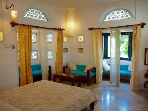 - une chambre avec 2 lits, un canapé et des fenêtres dans l'établissement Dia Homestay, à Pushkar