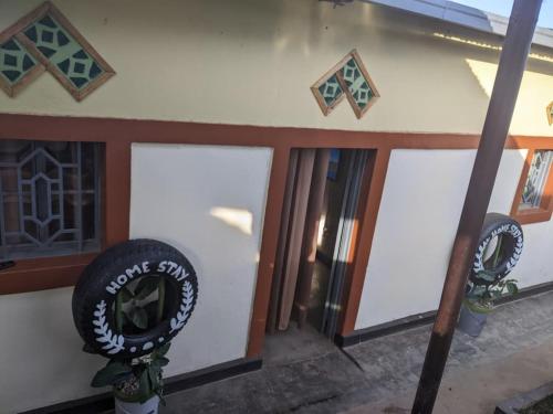 un bâtiment avec trois portes de garage et un panneau sur celui-ci dans l'établissement Akagera Homestay Experiences, à Rwinkwavu