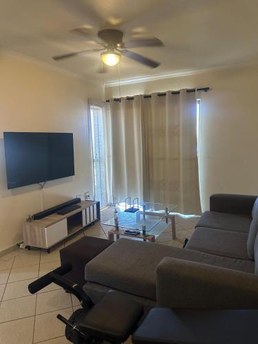 Una sala de estar con un sofá y un televisor de pantalla plana. en Unit 2B Sun And Surf, en KwaDukuza