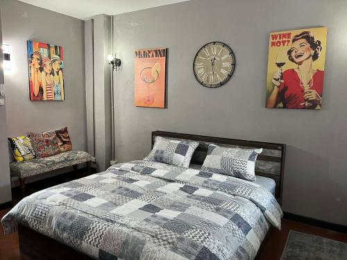 a bedroom with a bed and a clock on the wall at Nong Hoi house in Ban Nong Chaeng