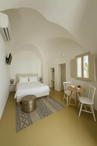 a bedroom with a bed and a table and chairs at B&B Palazzo Boccaccio in Matino