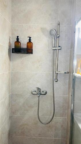 a shower with a shower head in a bathroom at Boulevard apartament in Sighetu Marmaţiei