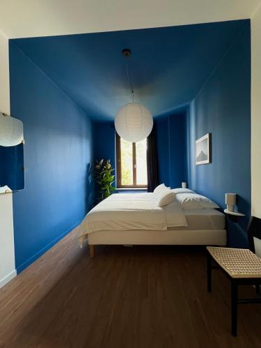 a blue bedroom with a bed and a window at Atelier Noé NOIR - Kunstvoll Wohnen - Wunderbares Frühstück möglich - Ruhig und nah am Zentrum - in Chemnitz