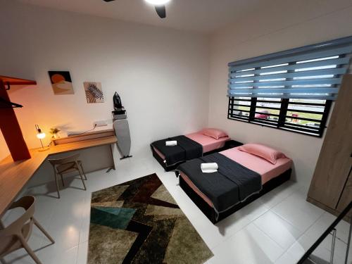 a bedroom with two beds and a desk and a window at Homestay Kesidang in Seri Iskandar