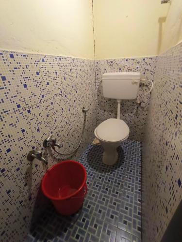 a bathroom with a toilet and a bucket at Munnar home stay in Munnar