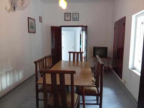 a dining room with a wooden table and chairs at Crystal Waters in Habaraduwa