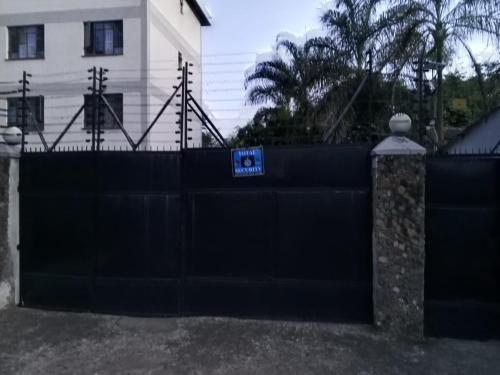 Una cerca negra con un cartel encima. en Rehema Apartments, en Kisumu