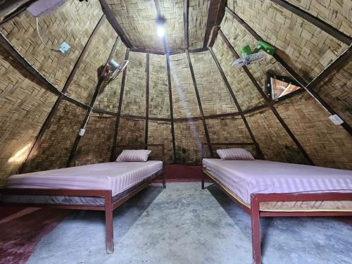 two beds in a room with a roof at The Last Resort in Don Det