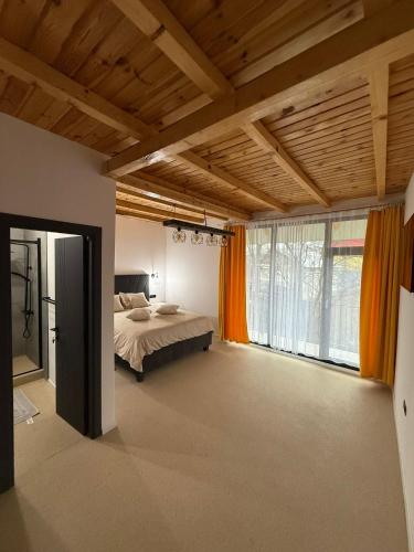 a bedroom with a bed and a large window at Zen Resort and Winery in Slănic