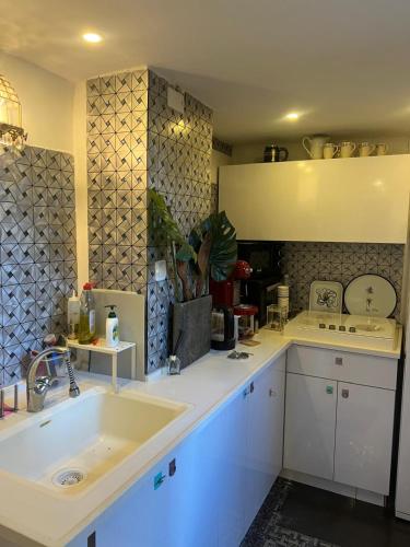 a kitchen with white cabinets and a sink at PARADISE in IR YAMIM in Netanya