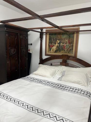 un lit avec une tête de lit en bois et une peinture murale dans l'établissement PARADISE in IR YAMIM, à Netanya