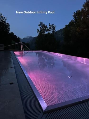 a large swimming pool with pink lights on it at Les Dolomites Mountain Lodges in San Martino in Badia