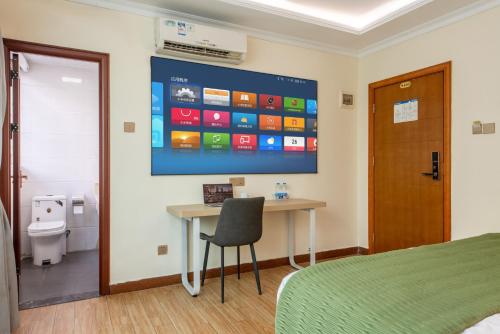 une chambre d'hôpital avec un bureau et un ordinateur fixé au mur dans l'établissement Sanjun Hotel, à Canton