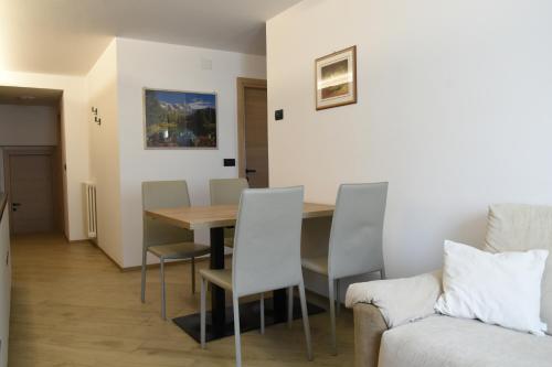 una sala da pranzo con tavolo, sedie e divano di Appartamento Margherita a Panchia