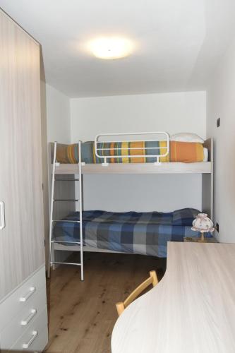 una camera con due letti a castello e un tavolo di Appartamento Margherita a Panchia