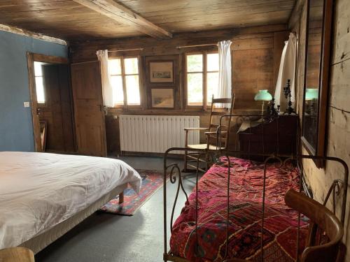 a bedroom with a bed and a table and window at Chalet Suvay in La Chapelle-dʼAbondance