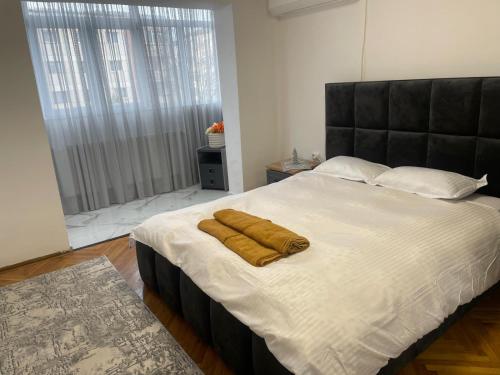 a bedroom with a large bed with two towels on it at Apartamentul lui Radu in Caracal