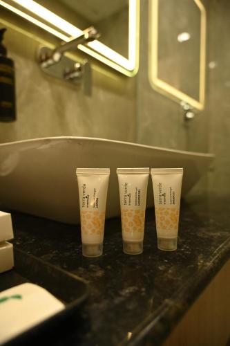 cztery kubki stojące na blacie w łazience w obiekcie The Regal Crown By Ritya Hotels w mieście Ayodhya