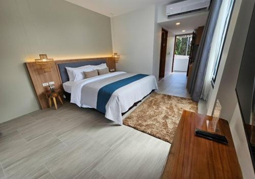 una habitación de hotel con una cama y un televisor en La La Lay Beach House, en Tab Kaek