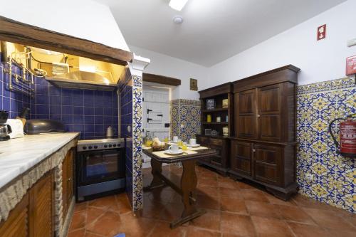 a kitchen with blue tiled walls and a small table at Villa Monte Domingos Simoes in Sesmarias