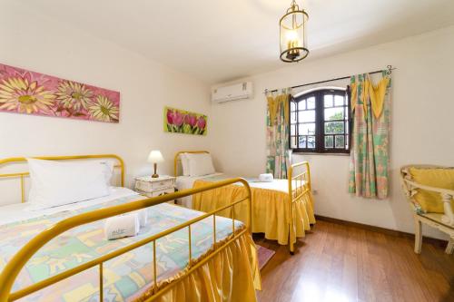 a room with two beds and a window at Villa Monte Domingos Simoes in Sesmarias
