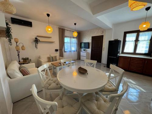 a living room with a white table and chairs at Palm Villa in Skala Sotiros