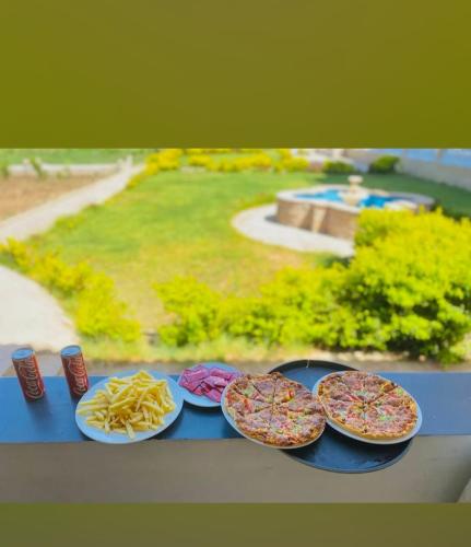 a table with four plates of food and fries at Leyla Eco Resort Queen Suites in Luxor