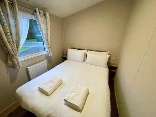 En eller flere senge i et værelse på Modern caravan - Whitecliff Bay