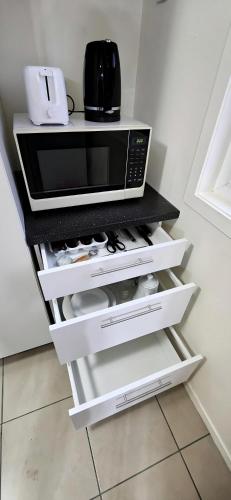 a microwave oven sitting on top of a counter at Entire House 15 min CBD Near Beach Mall and Nature in Auckland
