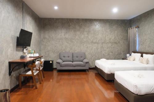 a hotel room with two beds and a chair at Momento House in Phra Nakhon Si Ayutthaya