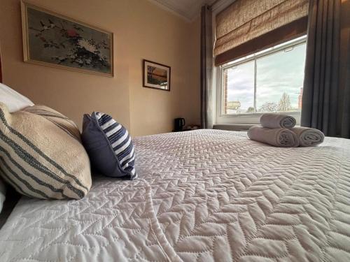 a bedroom with a large bed with pillows and a window at Tramway Hotel in Pakefield