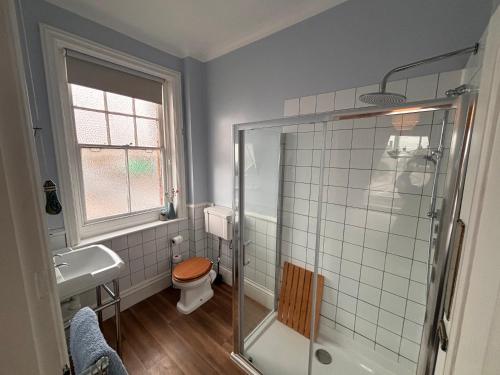 a bathroom with a shower and a toilet and a sink at Tramway Hotel in Pakefield