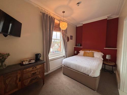 a bedroom with a bed and a window at Tramway Hotel in Pakefield