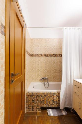 a bathroom with a tub and a shower curtain at Peace View Kea in Péra Meriá