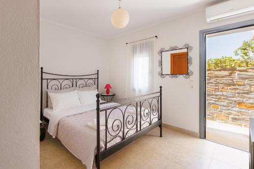 Un dormitorio con una cama y una ventana grande en Peace View Kea, en Péra Meriá