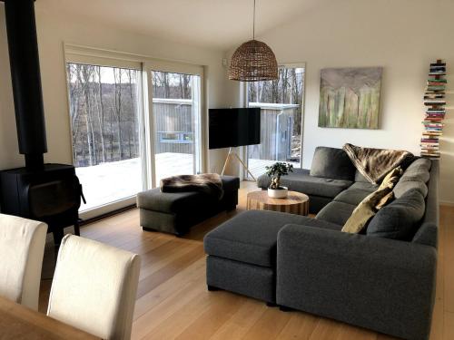 una sala de estar con un sofá y una silla en Stunning, modern home with a lakeview, en Äspered