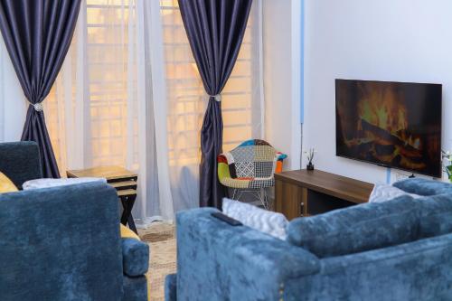 基苏木Mina Homes的客厅里有两把蓝色椅子和一台电视