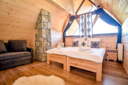 a bedroom with a bed in a log cabin at Bukowiańska Osada in Bukowina Tatrzańska